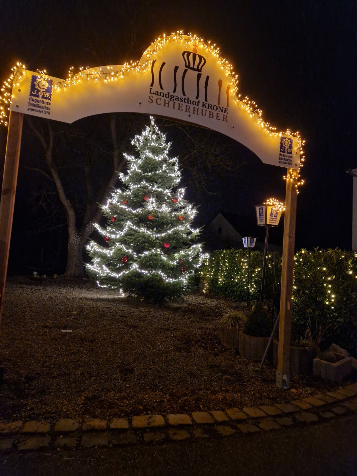 Eingangsbogen mit Logo und Christbaum im Advent