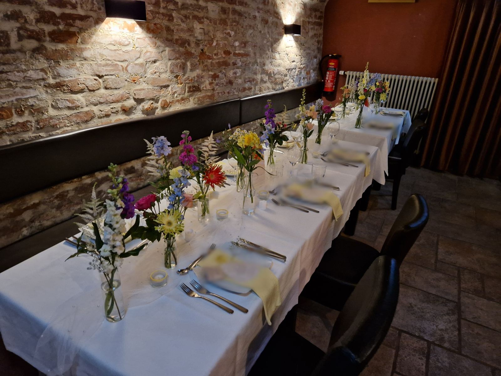 Hochzeitstafel mit Blumenschmuck im Gewölbekeller