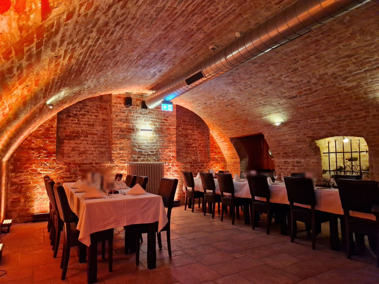 Vaulted cellar in Christmas lighting with laid tables